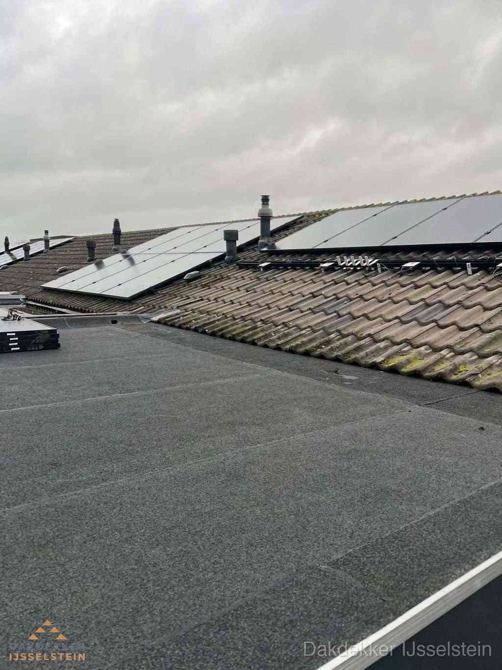 Plat dak inspectie met bitumen bedekking naast schuin pannendak in IJsselstein