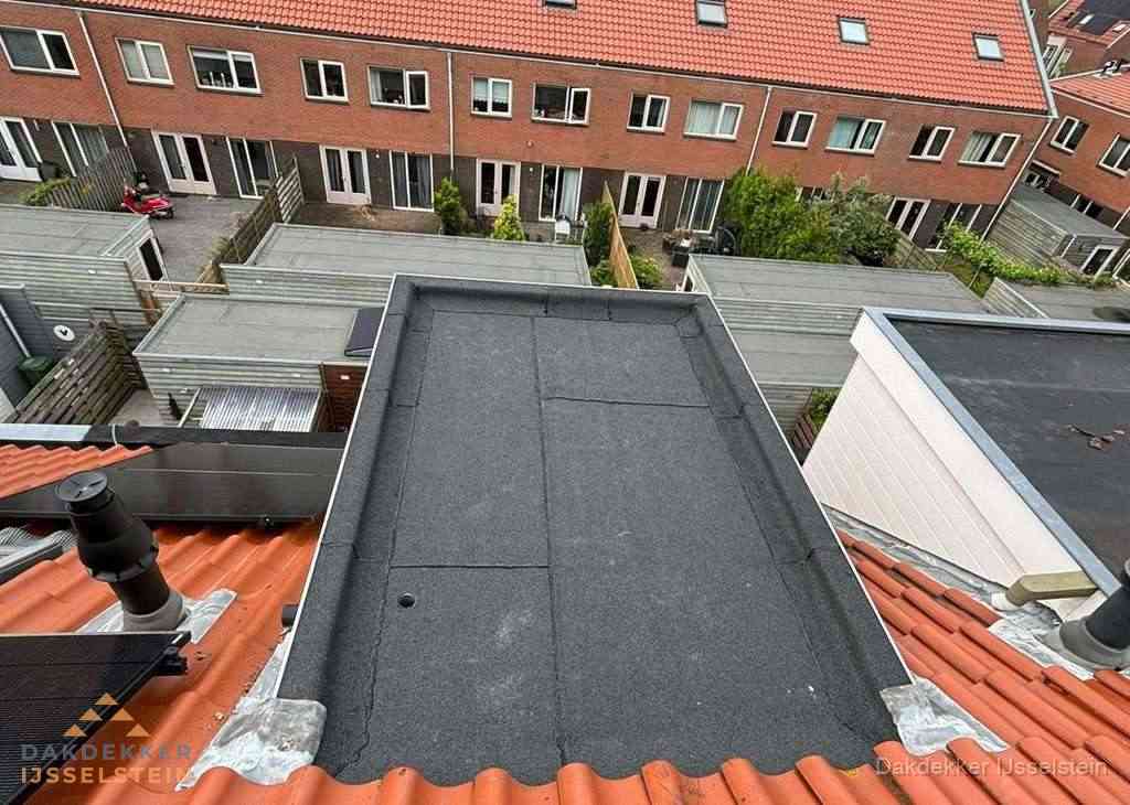 Plat dak met bitumen bedekking naast dakkapel in IJsselstein