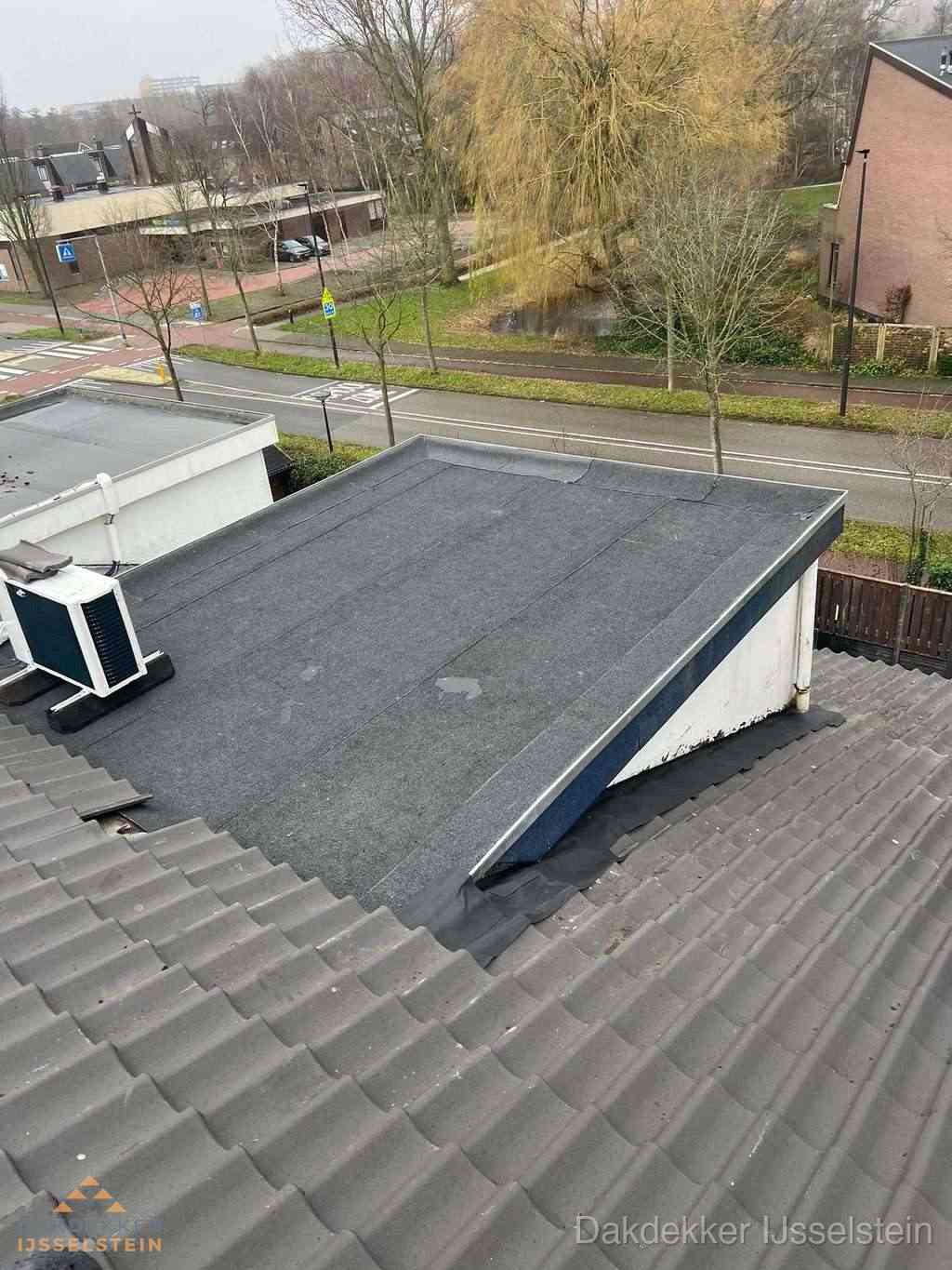 Plat dak met bitumen dakbedekking naast schuin pannendak in IJsselstein