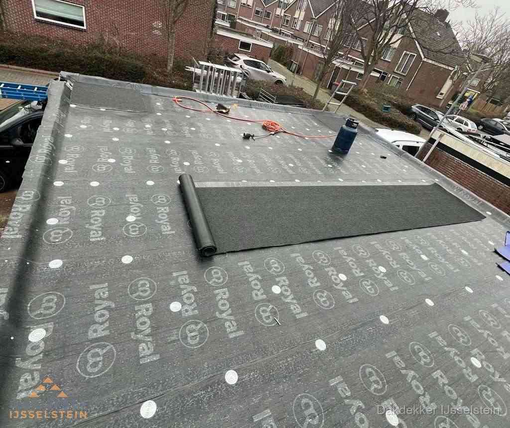 Dakdekker aan het werk met gasbrander op plat bitumen dak in IJsselstein
